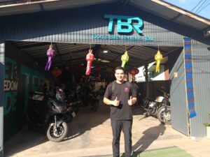 Man from Thailand outside a motorbike rental shop which signed up to Byklo