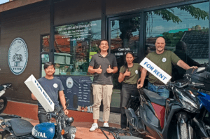 People standing outside motorbike rental shop in Chiang Mai. Byklo employee and owners and staff of Classic Bike Tour Thailand outside the motorbike rental shop