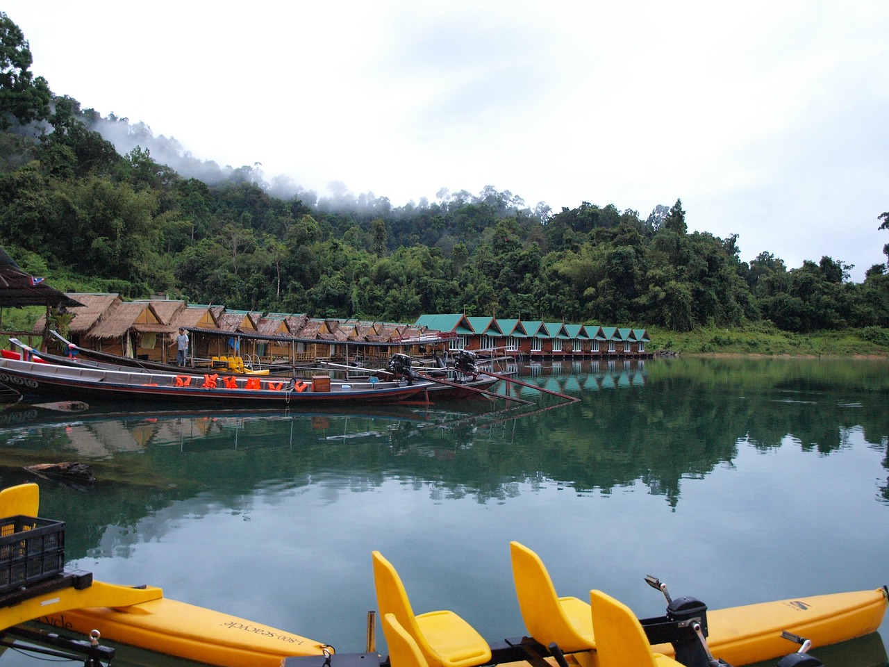 Khao Sok National Park: A Must-Visit Destination from Krabi Floating houses in Khao Sok, Thailand. People working on boats nearby.