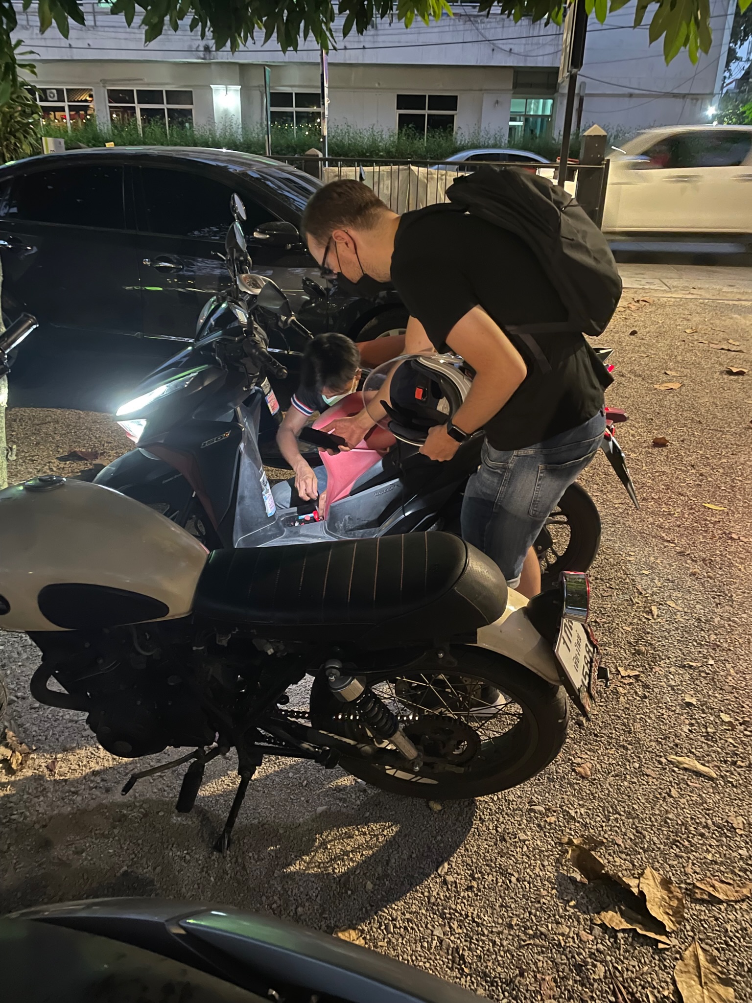 Top 10 Tips for Staying Safe While Riding a Motorbike in Thailand People checking a motorbikes battery. Mechanic helping customer to fix, Chiang Mai