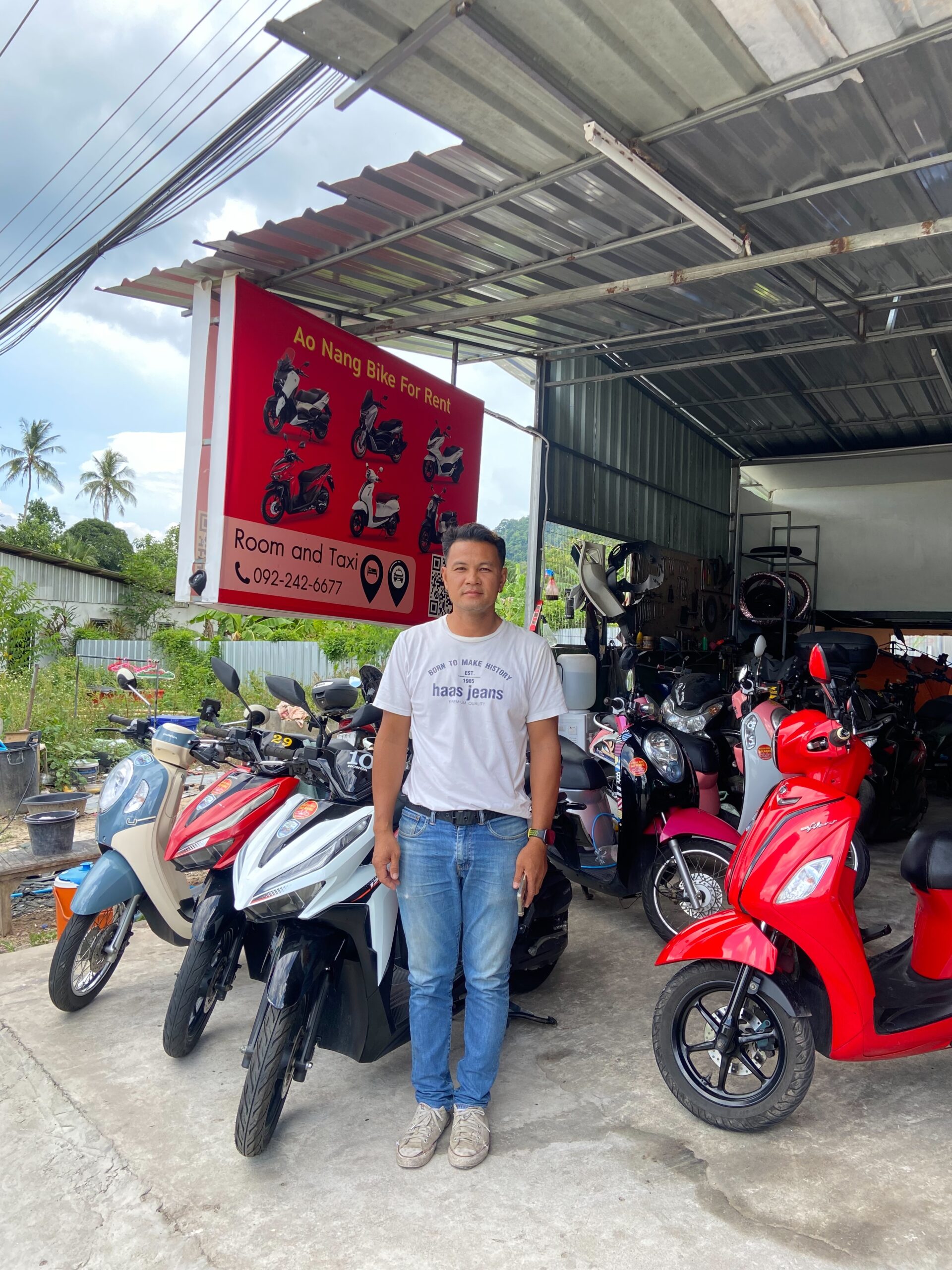 Ao Nang Bike For Rent Joins Byklo: Your Reliable Motorbike Rental Ao Nang Bike For Rent. Owner standing outside Ao Nang Bike For Rent shop in Ao Nang, Krabi. Motorbike beside him and sign with logo and motorcycles.