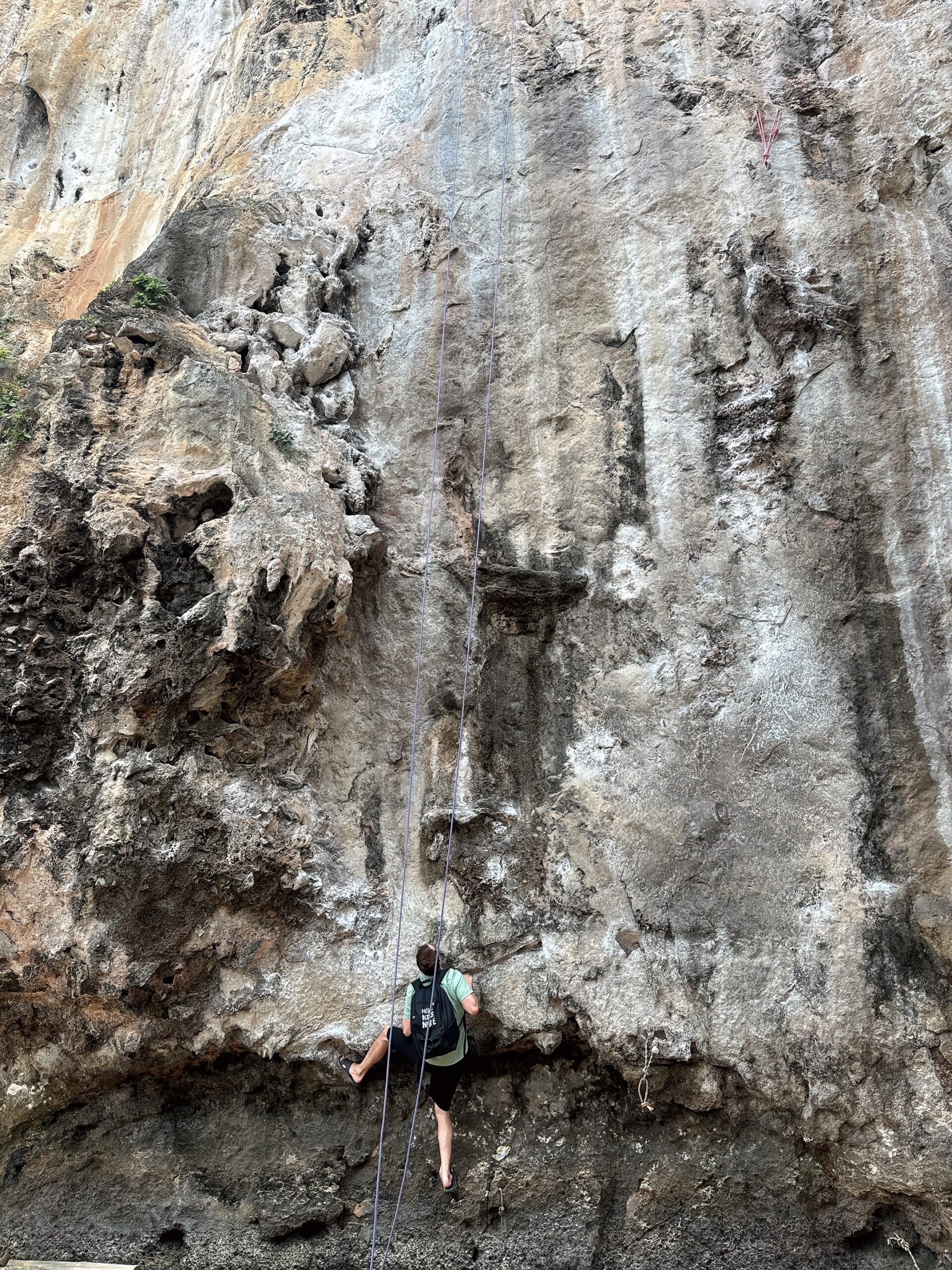 top 10 climbings spots in Krabi. Man free climbing a wall in Railay beach.