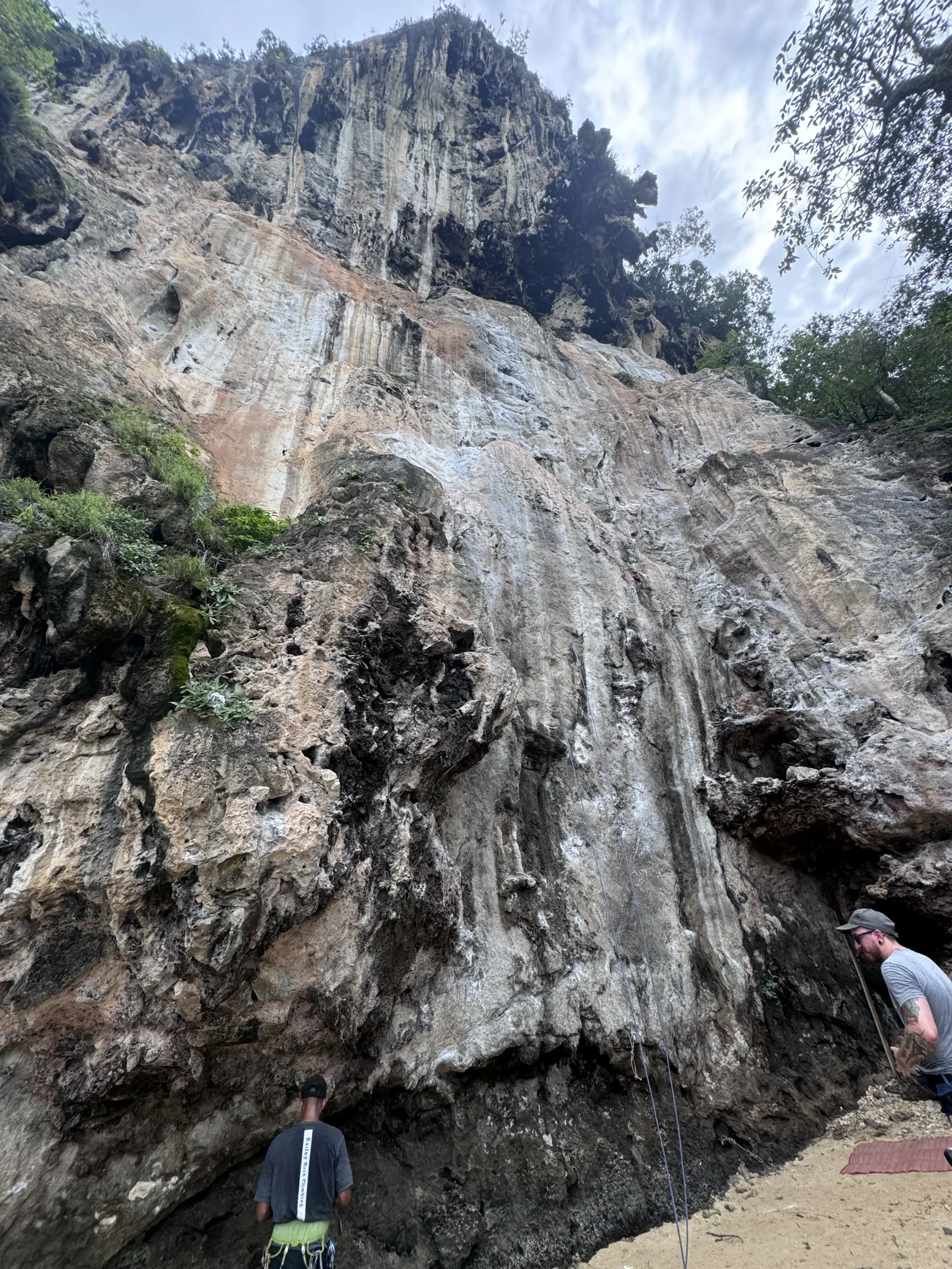 East Railay, Krabi. People preparing to climb the wall. Instructor talks to customer.